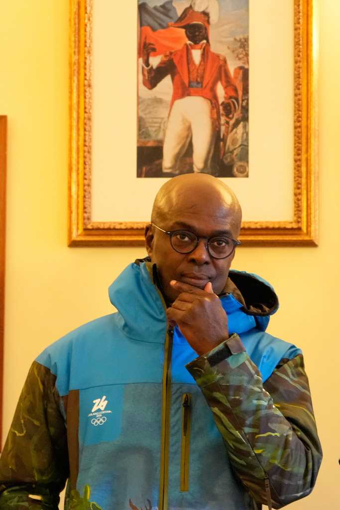 Haiti&amp;apos;s Ambassador to Italy, Gandy Thomas, poses at the Haitian Embassy in Rome, Saturday, Jan. 31, 2026, with the official uniform for the Haitian national team participating in the 2026 Winter Olympics. (AP Photo/Gregorio Borgia)