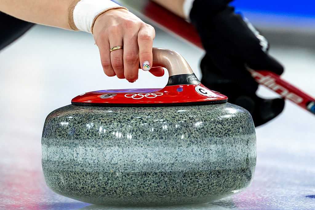 TOPSHOT - A nail with the Olympic rings logo is seen on the right hand of Denmark&amp;apos;s Jasmin Holtermann as she holds the stone during the curling women&amp;apos;s round robin between Denmark and Japan during the Milano Cortina 2026 Winter Olympic Games at the Cortina Curling Olympic Stadium in Cortina d&amp;apos;Ampezzo on February 12, 2026. (Photo by Odd ANDERSEN / AFP via Getty Images)