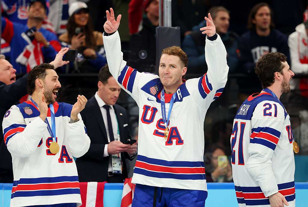Gold medalists Vincent Trocheck #16m Matthew Tkachuk #19 and Dylan Larkin #21 of Team United States celebrate during the medal ceremony following the Men's Gold Medal match between Canada and the United States on day 16 of the Milan Cortina 2026 Winter Olympic Games at Milano Santagiulia Ice Hockey Arena on February 22, 2026 in Milan, Italy.