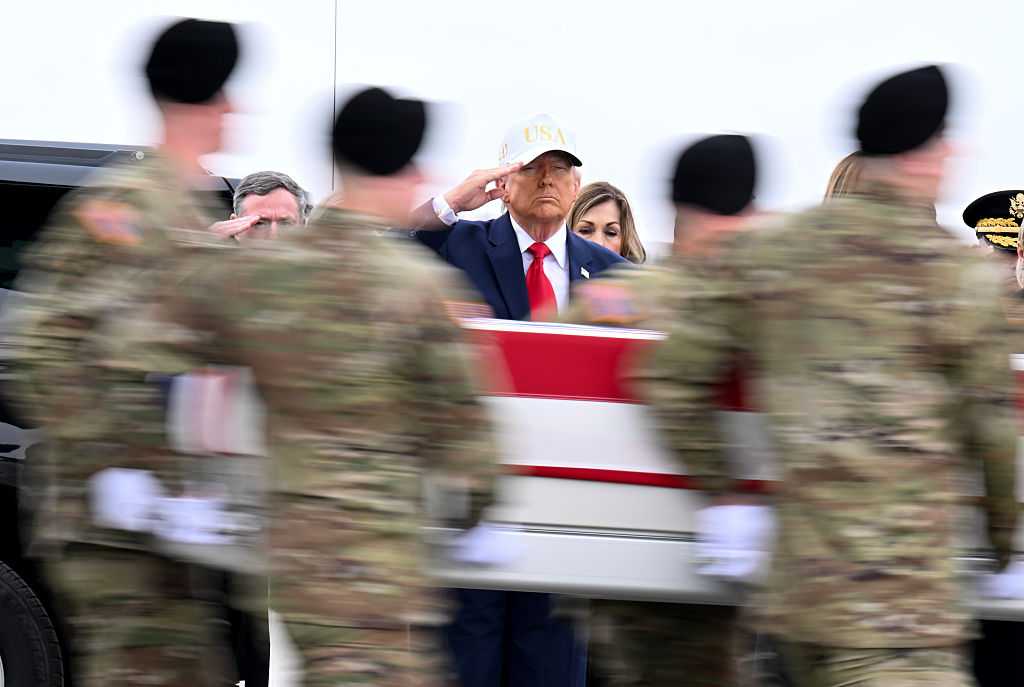 DOVER, DELAWARE - MARCH 07: U.S. President Donald Trump salutes as a U.S. Army carry team moves a flagged-draped transfer case containing the remains of Sgt. Declan J. Coady at Dover Air Force Base on March 07, 2026 in Dover, Delaware.  Six soldiers from the 103rd Sustainment Command were killed in action by an Iranian drone strike on March 1 in Port Shuabia, Kuwait during &amp;quot;Operation Epic Fury&amp;quot;. (Photo by Roberto Schmidt/Getty Images)