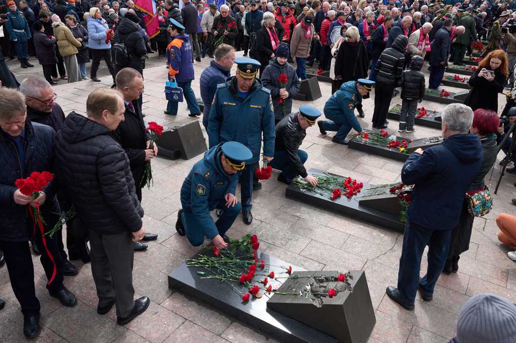 Russian Emergency Ministry troops and veterans lay flowers at the graves of firefighters at the Mitinskoye Cemetery where several victims of the Chernobyl nuclear disaster are buried, marking the 40th anniversary of the explosion and fire at the Chernobyl nuclear power plant in Ukraine, outside Moscow, Sunday, April 26, 2026.
