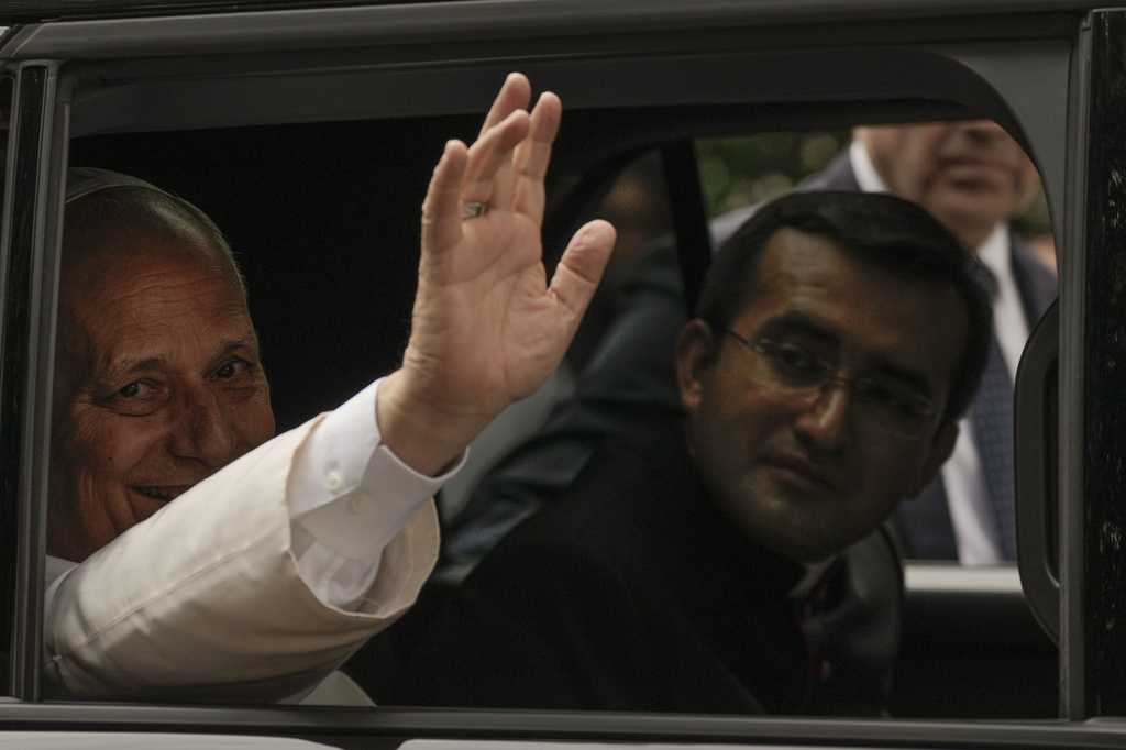 Pope Leo XIV waves from his car as he leaves with his personal secretary, Monsignor Edgard Iván Rimaycuna Inga, right, after visiting the Città Universitaria (University City) at Sapienza University of Rome where he met with faculty and students at the institution&amp;#39;s primary campus, one of the world&amp;#39;s oldest and largest universities, Thursday, May 14, 2026.