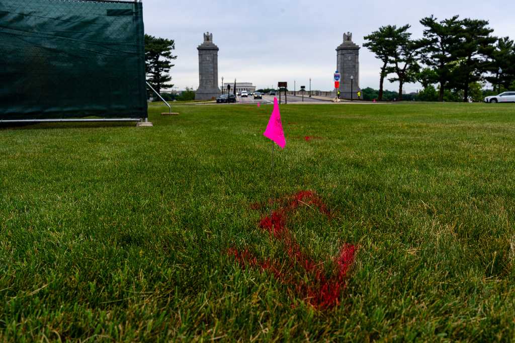 Flags are placed as workers survey the Memorial Circle, where President Donald Trump has proposed building an arch to commemorate the United States&amp;#39; 250th anniversary, Monday, May 11, 2026, in Washington. (AP Photo/Alex Brandon)