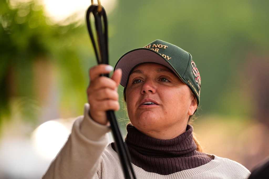 Trainer Cherie DeVaux stands watches from a barn after a workout at Churchill Downs Monday, April 27, 2026, in Louisville, Ky.